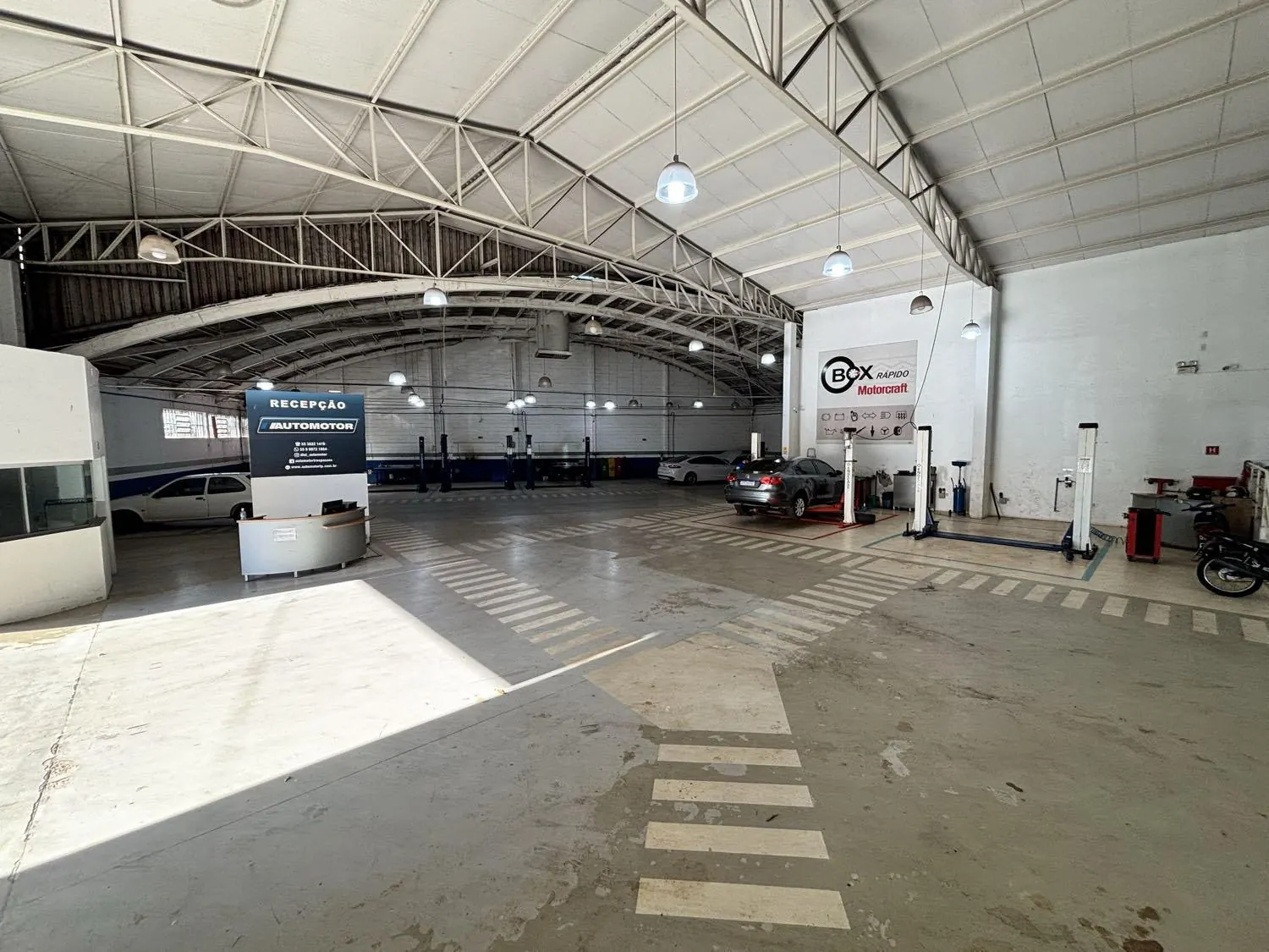 Interior da oficina Automotor com elevadores e recepção